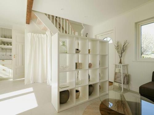 a white staircase in a living room with a glass table at Charming House At Häckeberga Nature Reserve in Svedala
