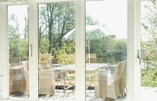an open window with a view of a patio with an umbrella at Charming House At Häckeberga Nature Reserve in Svedala