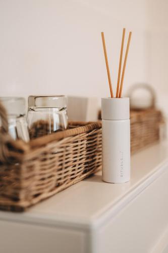 a white vase sitting on a shelf with baskets at Boutique Hotel Villa Monika in Westerland (Sylt)