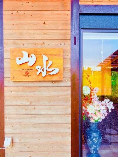 a sign on the side of a building with flowers at Shanshui House TAKASHIMA 一棟貸切 自炊BBQok in Takashima