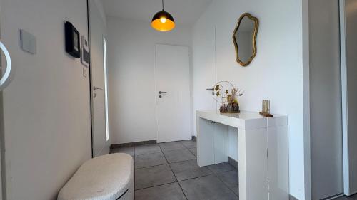 un couloir blanc avec une table et un miroir dans l'établissement Villa Prestige Piscine, barbecue, Clim, Jardin top prosconciergerie, à Cournonterral