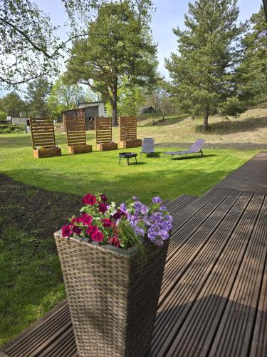 a planter with flowers on a deck with benches at Brīvdienu māja Jaunzvīņas in Upesgrīva