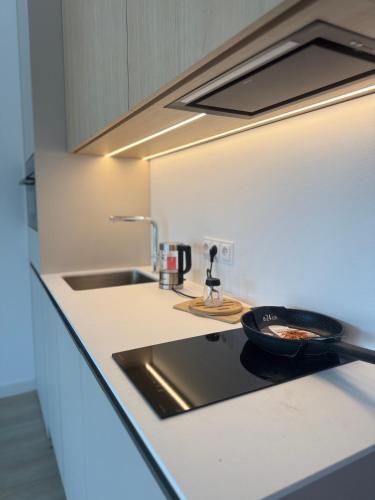 a kitchen counter with a frying pan on a stove at Baltic Infinity Beach Spa in Międzyzdroje