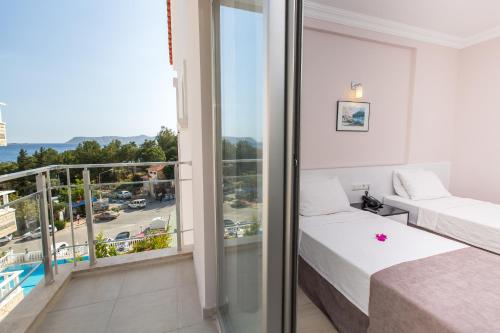 a hotel room with two beds and a balcony at Habesos Hotel in Kaş