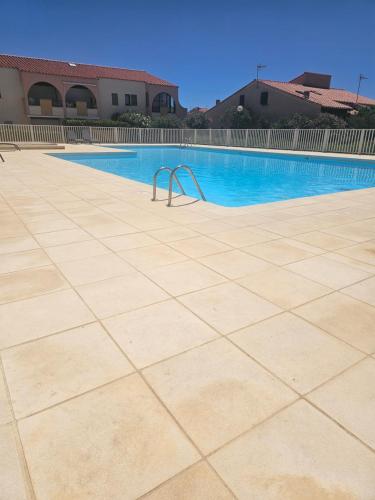 une piscine vide avec une balustrade en métal au milieu dans l'établissement Le Patio 6 Personnes Piscine Barcarès village, au Barcarès
