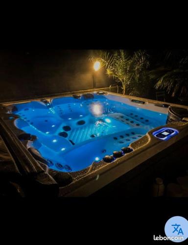 - une baignoire jacuzzi avec eau bleue dans la chambre dans l'établissement La Suite du Bouquet, à Cosqueville