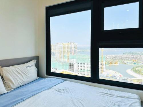 une chambre avec un lit et une grande fenêtre dans l'établissement Shi House -Studios Building GH2 Right at Vincom Q9, à Long Bình