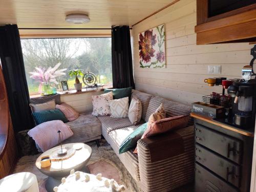 Una sala de estar con un sofá y una ventana. en Tiny House Dreiländereck, en Neu-Moresnet