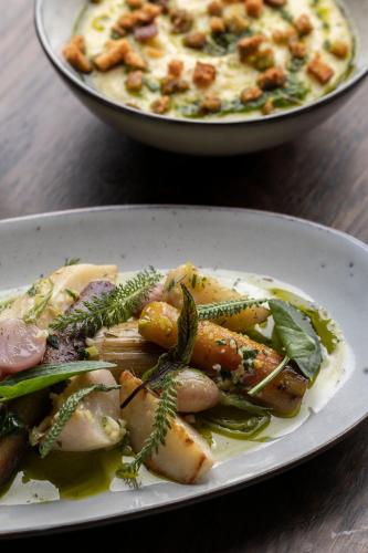 a plate of food with vegetables and a plate of pizza at Hôtel 48°Nord & Restaurant, The Originals Relais in Breitenbach