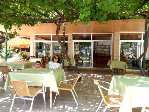 two women sitting at a table in a restaurant at Aysev Hotel in Alanya