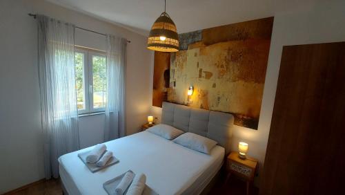 a bedroom with a bed with two towels on it at Apartments Batistić in Supetarska Draga