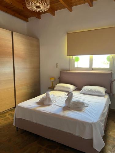 two swans sitting on a bed in a bedroom at Sweet Home in Amarinthos