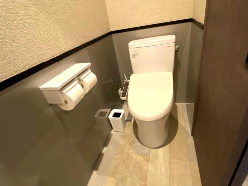 a bathroom with a toilet and two rolls of toilet paper at Condominium Hotel Mihama Upi in Chatan