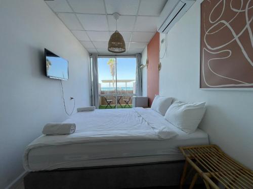 a bedroom with a large bed with a window at מלון סנטרל ביץ תל אביב in Tel Aviv