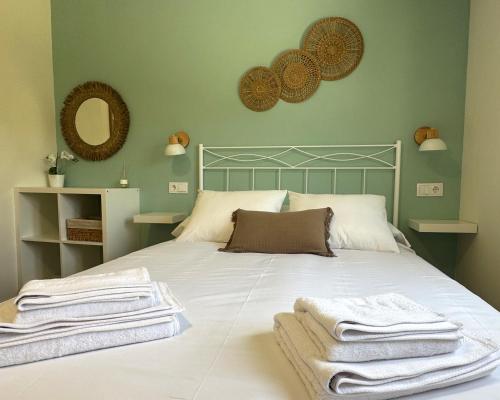 a bedroom with a bed with towels on it at As Cortiñas, casa vacacional completa en Laxe 