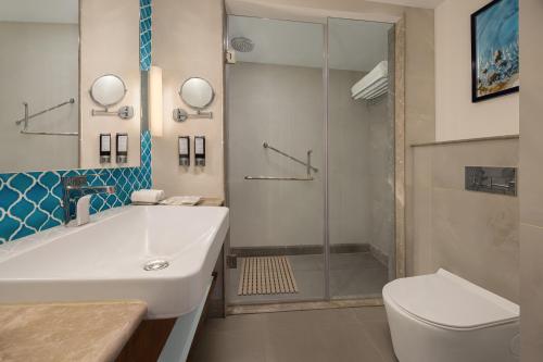 a bathroom with a toilet and a sink and a shower at Fortune Beachfront, Puri - Member ITC Hotels' Group in Puri