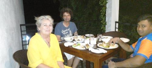 a group of people sitting at a table eating food at Samudra Luxe Resort in Habarana