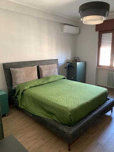 a bedroom with a bed with a green comforter at Penthouse in the historic center in Brindisi