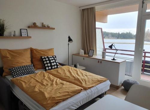 une chambre avec un lit avec des oreillers et une fenêtre dans l'établissement Lake Lodge am Kranichsee - Hahnenklee im Harz, à Goslar