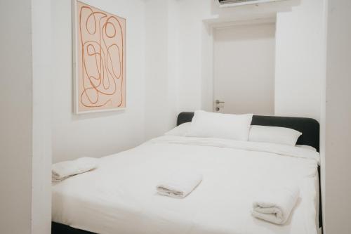 a bedroom with a white bed with a picture on the wall at מלון סנטרל ביץ תל אביב in Tel Aviv