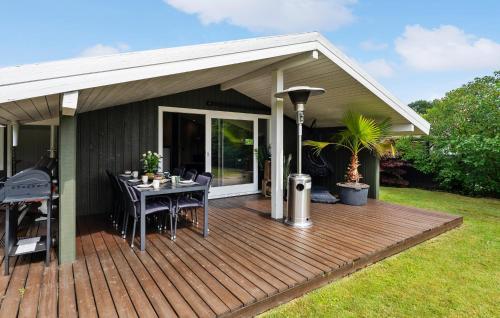a wooden deck with a dining table on it at 4 Bedroom Awesome Home In Otterup in Otterup