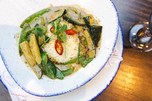 a bowl of food with rice and vegetables on a table at Leonardo Hotel Dublin Christchurch in Dublin