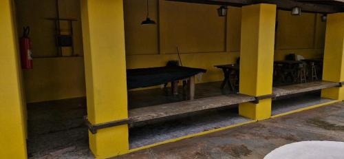 a room with yellow columns and a table in it at Pousada Boa Vista in Brotas