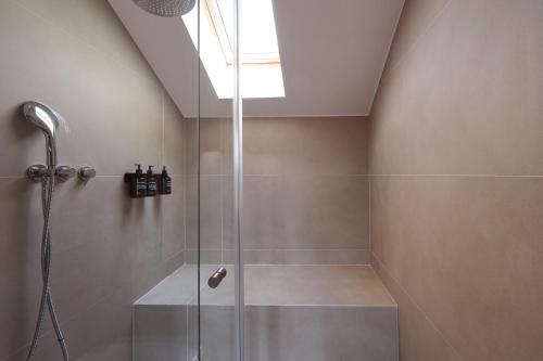 a bathroom with a shower with a glass door at Casa Teva Lisboa Boutique Hotel by chic&basic in Lisbon