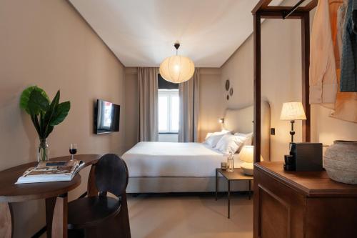 a hotel room with a bed and a table and a desk at Casa Teva Lisboa Boutique Hotel by chic&basic in Lisbon