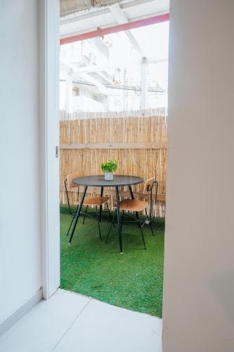 a table and chairs in a yard with a fence at מלון סנטרל ביץ תל אביב in Tel Aviv