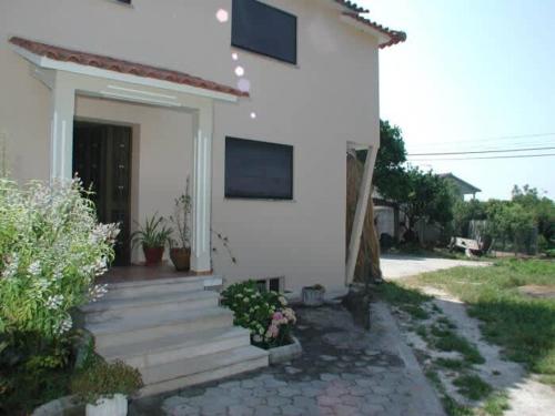 a small white house with a porch and stairs at Casa Caetano in Souto da Carpalhosa