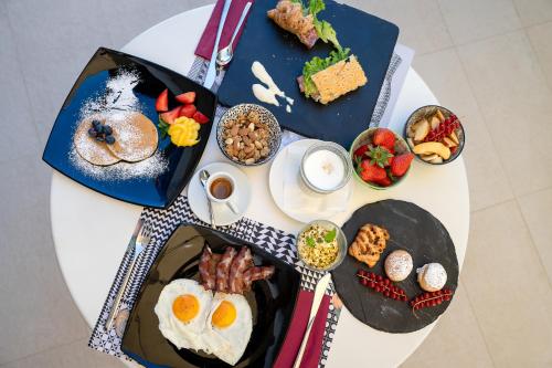 een witte tafel met borden ontbijtproducten bij Hotel Tiffany & Resort in Cesenatico