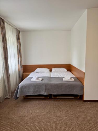 a bedroom with a bed with two towels on it at Alanta "Easy Kaunas" in Kaunas
