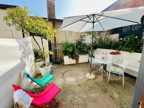 a patio with a table and chairs and an umbrella at New Apartment on Ground Floor with Terrace in Desenzano del Garda