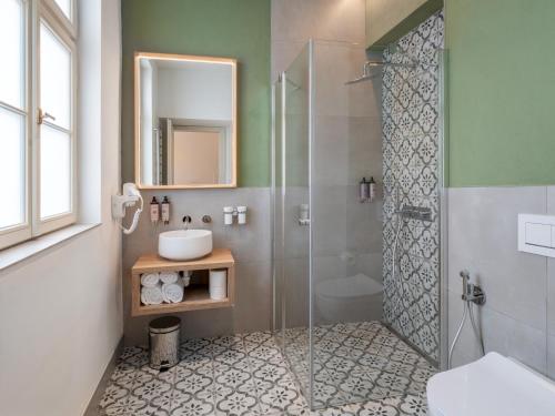 a bathroom with a glass shower and a sink at The Botanist by Adrez in Prague