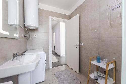 a bathroom with a sink and a toilet and a mirror at Talea Holiday Apartments 1 in Lezhë