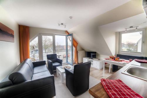ein Wohnzimmer mit einer Couch und einem Tisch in der Unterkunft Dünenglück, Ferienwohnung 33 in Cuxhaven