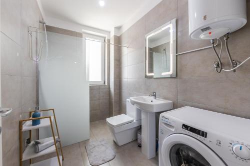a bathroom with a washing machine and a sink at Talea Holiday Apartments 1 in Lezhë