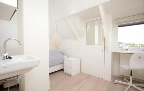a white bathroom with a sink and a mirror at 'T Sterntje in Bergen aan Zee