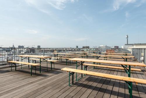 a row of wooden benches on a deck at a&o Hamburg City in Hamburg