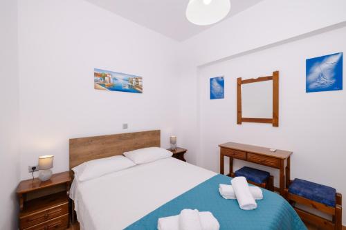 a bedroom with a bed and a desk and a mirror at Stegnailion in Archangelos