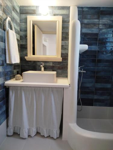 a bathroom with a sink and a mirror and a tub at Pano Chorio Tilos in Megálon Choríon