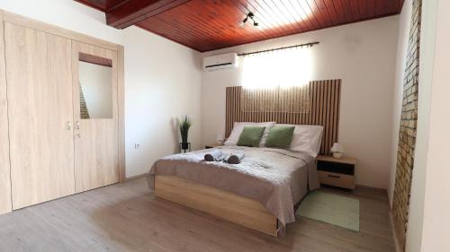 a bedroom with a bed with green pillows at Holdvirág Vendégház in Jánoshalma