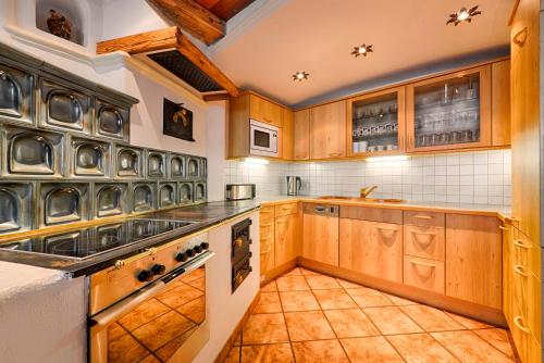 a kitchen with wooden cabinets and a tile floor at Ferienhaus Grabenhäusl in Grossarl