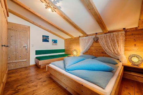 a bedroom with a large wooden bed with blue pillows at Ferienhaus Grabenhäusl in Grossarl