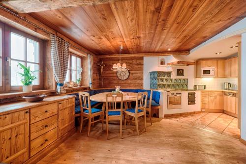 a kitchen with a wooden ceiling and a table with chairs at Ferienhaus Grabenhäusl in Grossarl