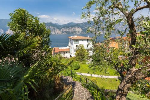 a house on a hill with a view of the water at Hotel Vega in Malcesine