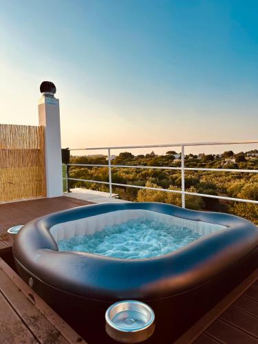 a jacuzzi tub on a deck with a lighthouse at Agape B&B Monopoli in Monopoli
