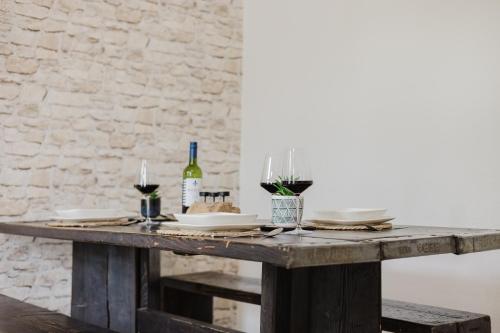 - une table en bois avec des assiettes et des verres à vin dans l'établissement Dessaus Motto Appartements! Solo - Pärchen - Familien - Gruppen, à Dessau