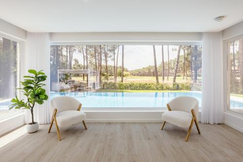 a living room with two chairs and a swimming pool at Aroeira Modern Grand Villa With Pool by Homing in Aroeira